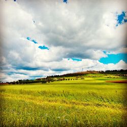 Scenic view of field against cloudy sky