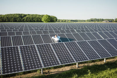 Mature man resting on panel in solar plant