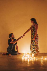 Full length of couple standing against wall