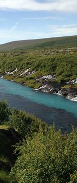 Scenic view of river against cloudy sky