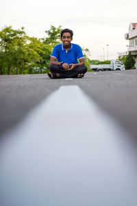Portrait of young man sitting on car