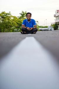 Portrait of young man sitting on car