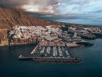 High angle view of city by sea against sky