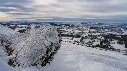 Aerial view of snow covered landscape against sky