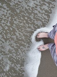 High angle view of hands on sand at beach