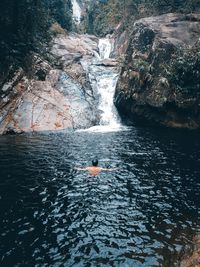 Man swimming at the waterfall