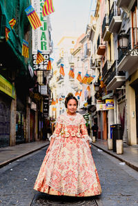 Portrait of woman on street amidst buildings in city