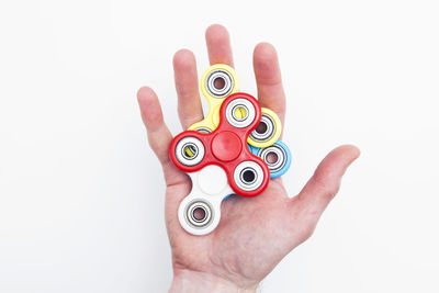 Cropped hand of woman holding pills against white background