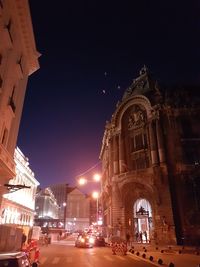 Statue in illuminated city against clear sky at night