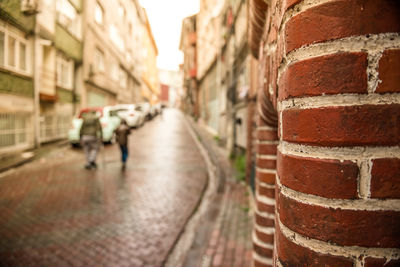 View of people walking on footpath amidst buildings