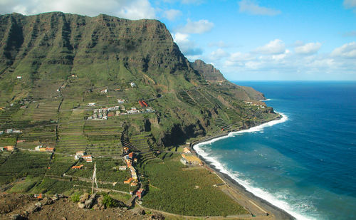 Scenic view of sea and mountains against sky