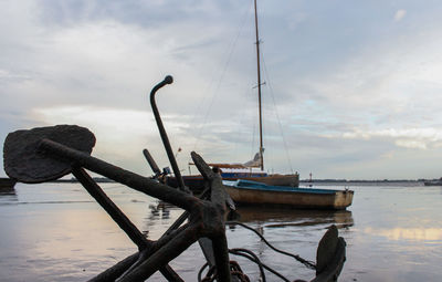 Fishing boats moored on sea against sky