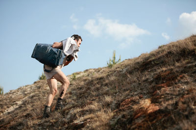 Low angle view of man climbing a hill