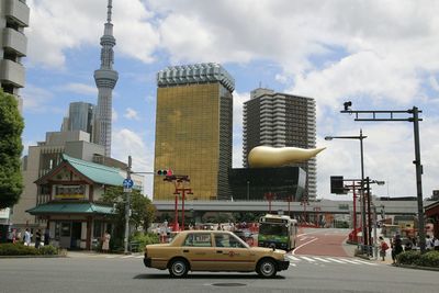 Cars on road against sky in city