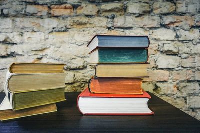 Close-up of books on table against wall