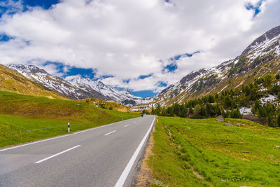 Road leading towards mountain against sky