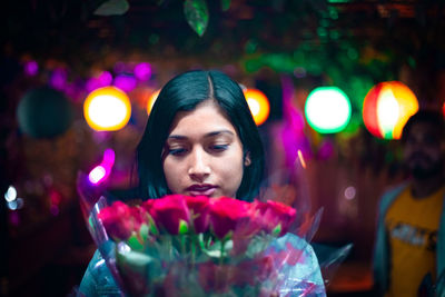 Portrait of young woman looking away at night