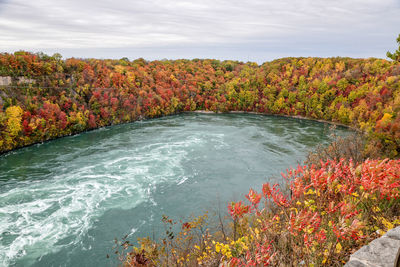 Scenic view of river amidst trees against sky during autumn