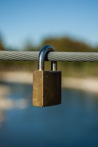 Close-up of padlocks on railing against river