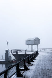 Stilt house on pier during foggy weather in winter