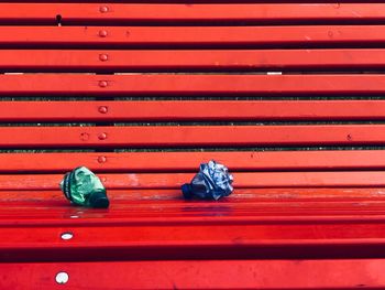 Crumpled bottles on red wooden bench