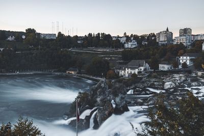 River amidst city against sky during winter