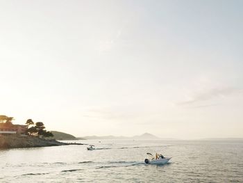 People traveling in boat on sea against sky