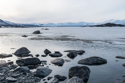 Scenic view of lake against sky during winter