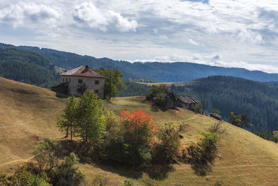 Scenic view of house and mountains against sky