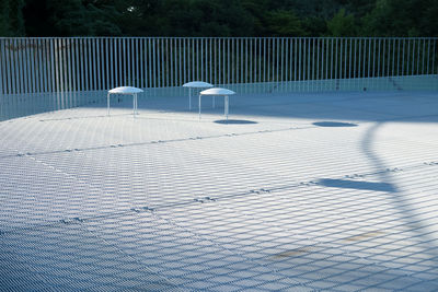 Shadow of fence on snow covered footpath