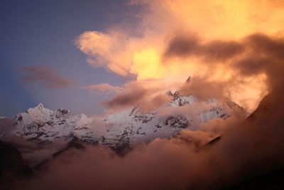 Scenic view of snow covered mountains during sunset