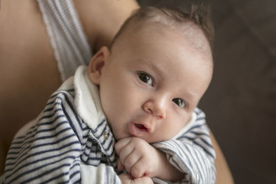 Midsection of mother carrying baby girl at home