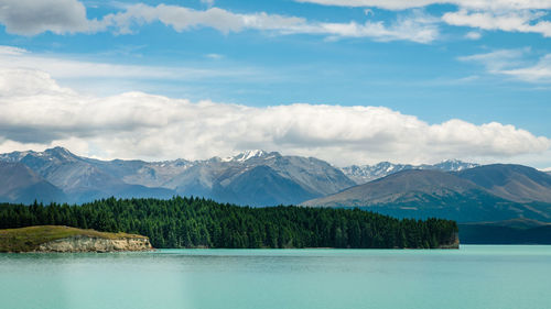 Scenic view of lake by mountains against sky