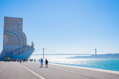 Bridge over sea against clear blue sky