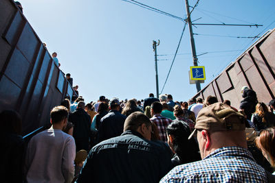 Low angle view of people in city against clear sky