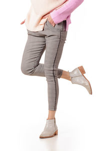 Low section of woman standing against white background