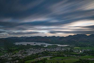 Aerial view of townscape and mountains against sky