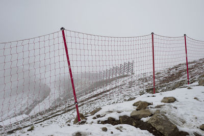 Red mesh in the mountains. restriction in the snowy mountains. low cloudy sky. fog. 