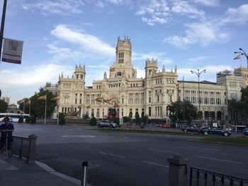 View of city street against cloudy sky