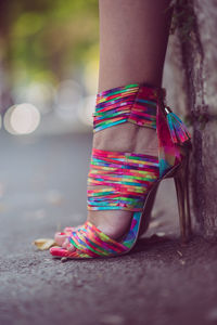 Low section of woman wearing colorful high heels