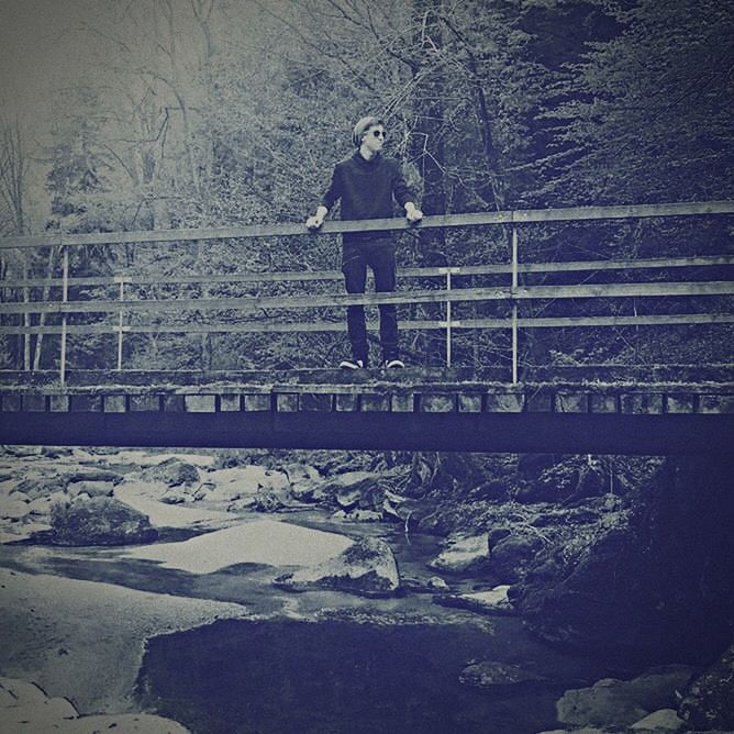 MAN STANDING ON SNOW COVERED LANDSCAPE