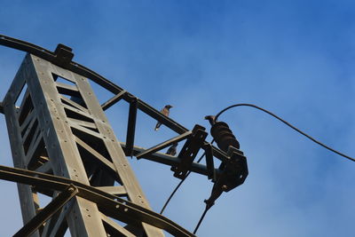 Low angle view of man working against sky