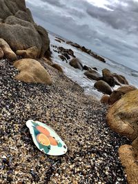 Surface level of stones on beach against sky