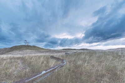 Scenic view of land and road against sky