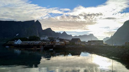 Scenic view of lake by houses against sky