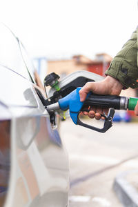 Young man refueling car at gas station