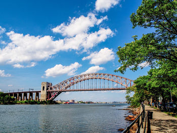 Bridge over river in city against sky