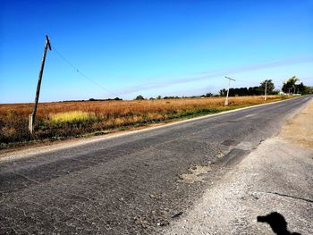 Country road against clear blue sky