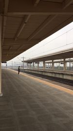 Man at railroad station against clear sky