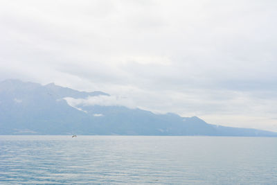 Scenic view of sea and mountains against sky